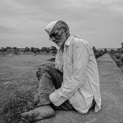 a farmer sitting peacefully near his animals.