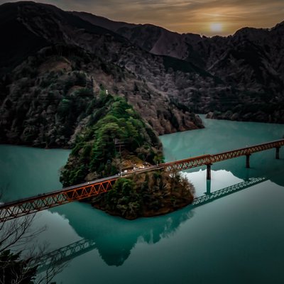 a railroad bridge spanning a green river🤩