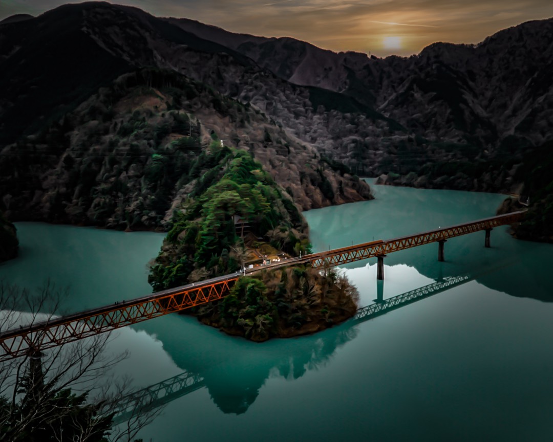 a railroad bridge spanning a green river🤩